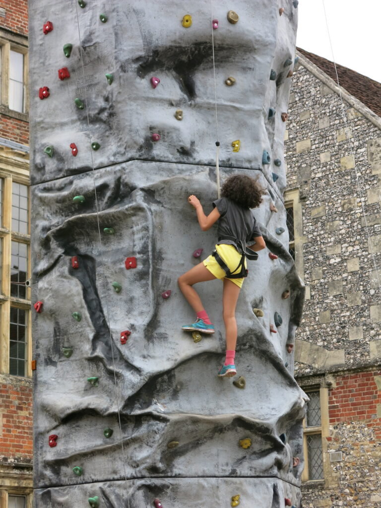 Young person climbing up the 'climb a monolith'